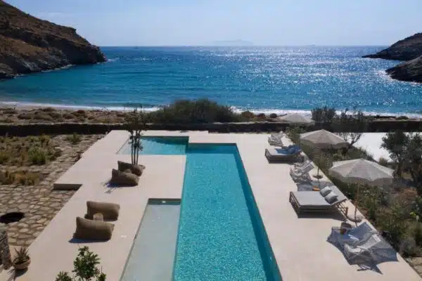 belle piscine et transat au bord de mer dans un hôtel avec des cours de yoga en Grèce