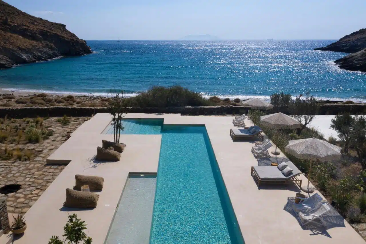 belle piscine et transat au bord de mer dans un hôtel avec des cours de yoga en Grèce