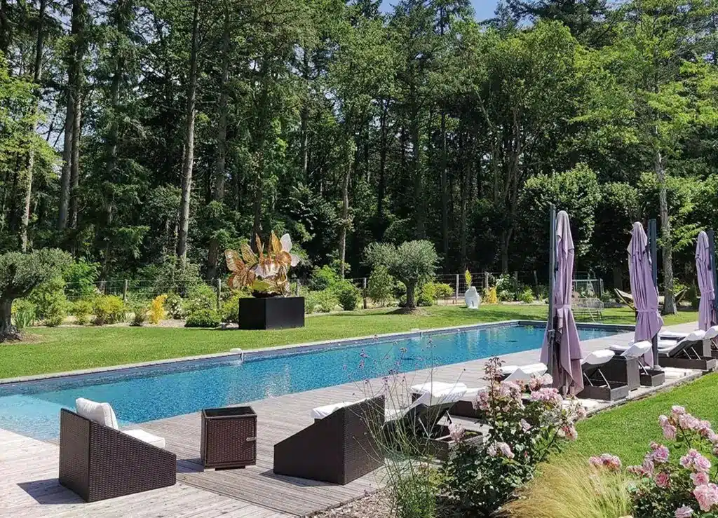 piscine extérieure avec transat et salon de jardin