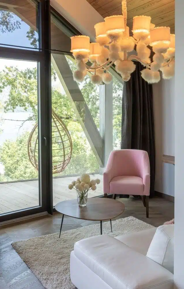 coin salon avec terrasse et fauteuil suspendu dans une chambre de la Villa Caroline, boutique hôtel bien-être sur le lac d'Annecy