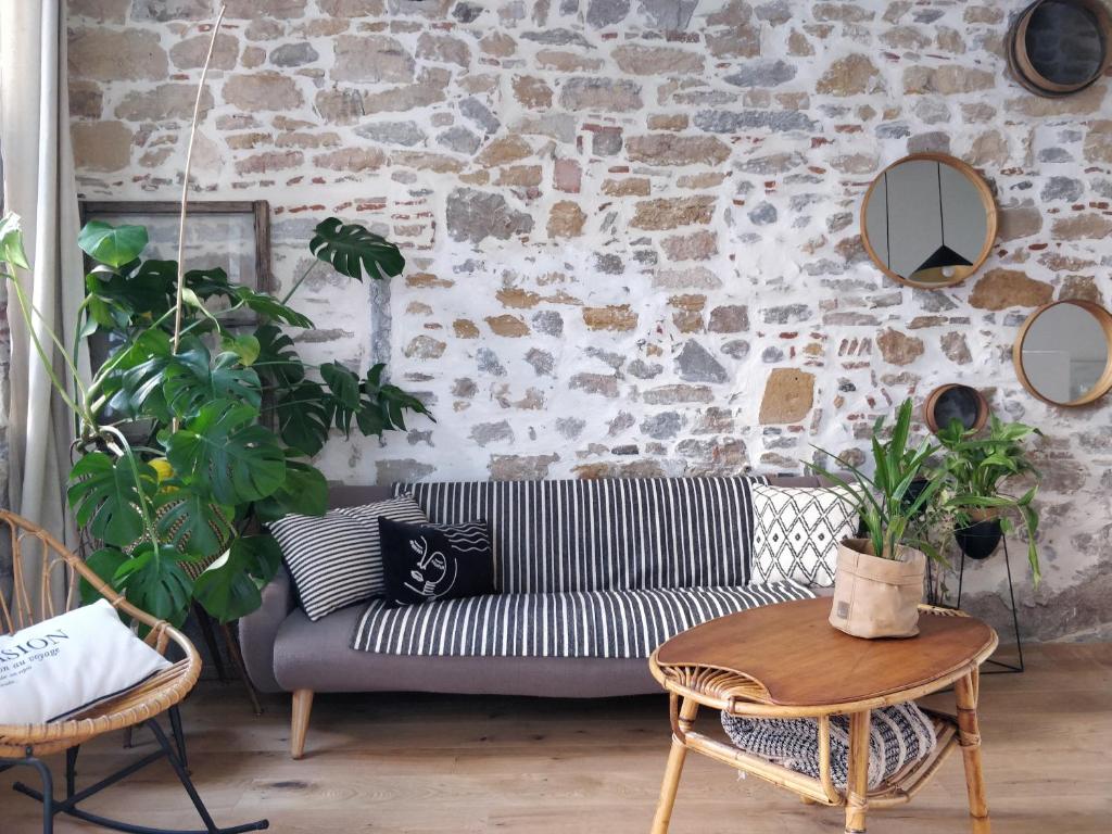 Salon avec mur en pierre apparente et parquet au sol pour cet appartement typique à la location touristique dans le Vieux Lyon