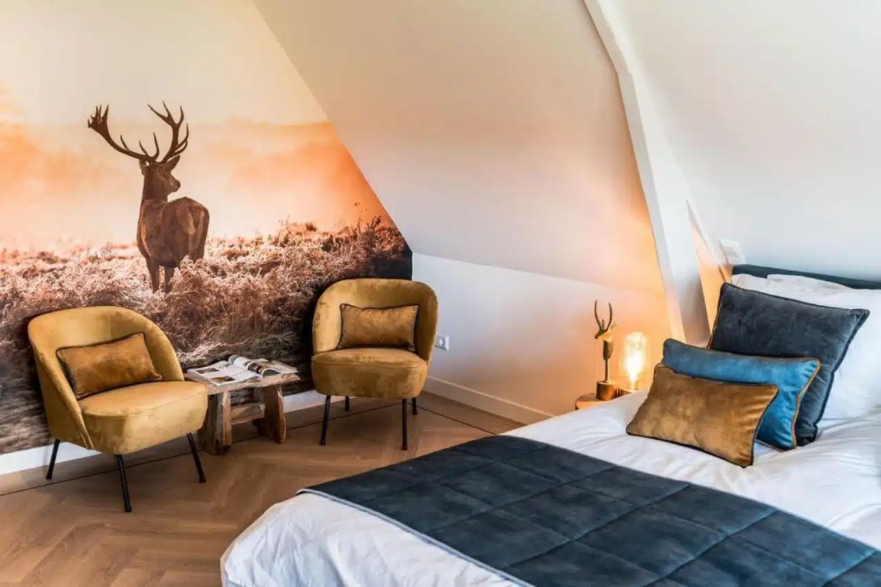 coin salon avec un grand cerf en papier peint dans une chambre double spacieuse