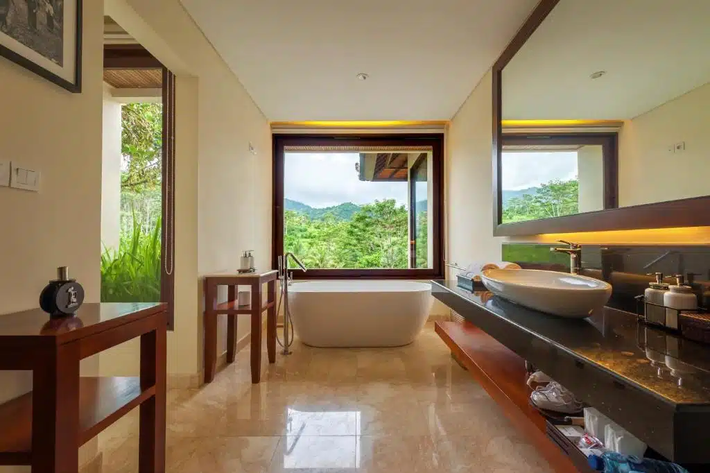 Salle de bain avec baignoire offrant une vue sur les rizières et le mont Agung