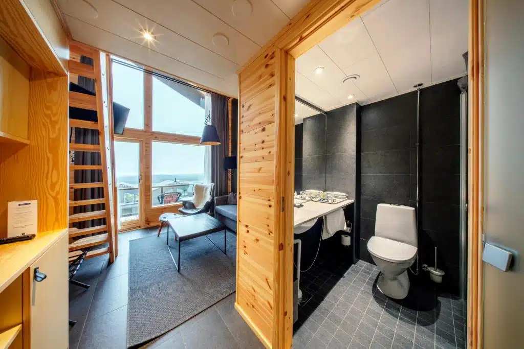 Chambre en duplex avec un canapé lit et une grande baie vitrée pour admirer le ciel et les aurores boréales