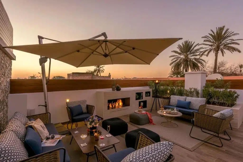 salon lounge extérieur cosy avec cheminée et vue sur les toits de Marrakech