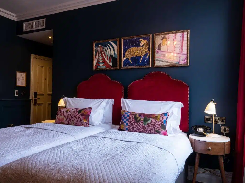 chambre d'hôtel twin avec tête de lit rouge sur mur bleu