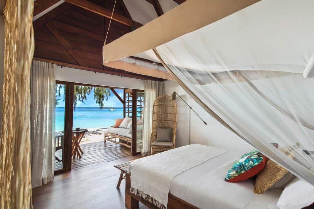 vue intérieure du bungalow avec le lit faisant face à la plage et à la mer paradisiaque