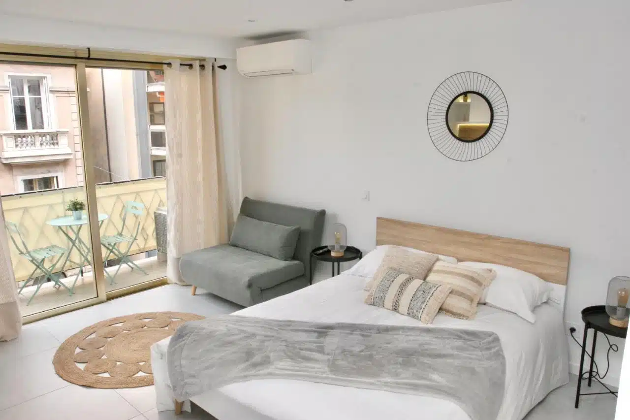 lit, fauteuil et balcon du studio airbnb Le Melsono dans le Carré d'Or de Nice
