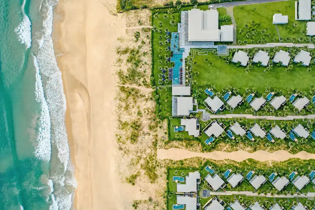 vue aérienne de l'hôtel et de la plage où les chambres sont des villas individuelles