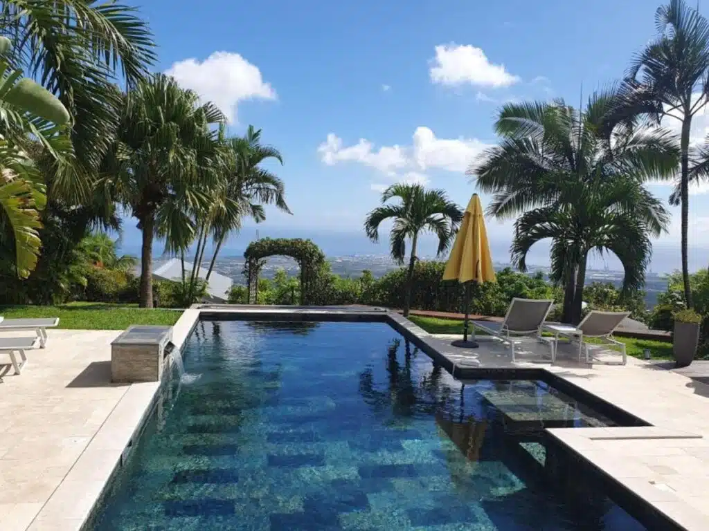 piscine en pierres naturelles avec vue panoramique sur Saint-Paul et l'océan